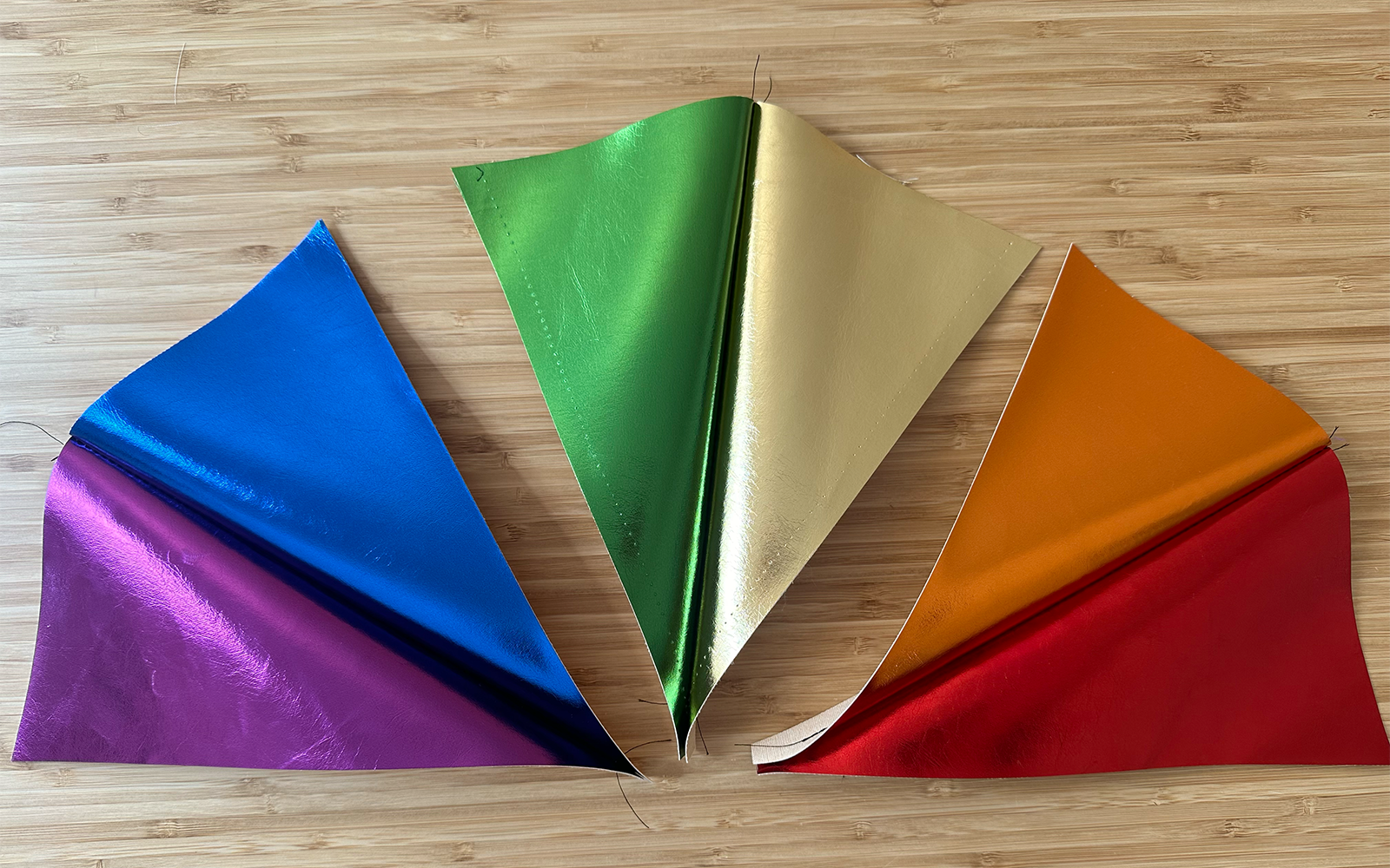  Dreieckige, regenbogenfarbene Plisseestücke, die in Zweiergruppen zusammengenäht werden