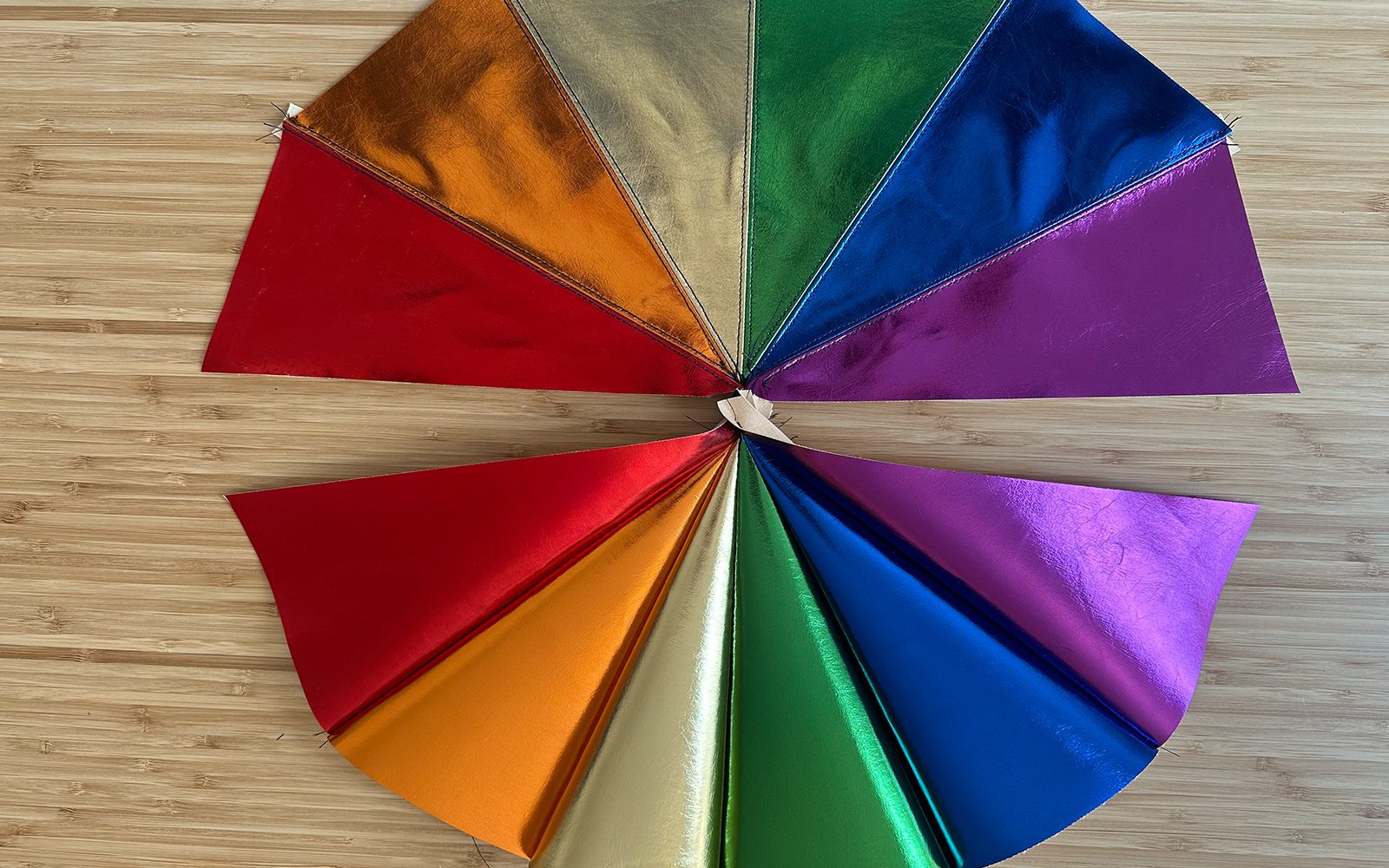 Zwei Fächer aus regenbogenfarbenem Kunstleder, einer mit Steppnähten