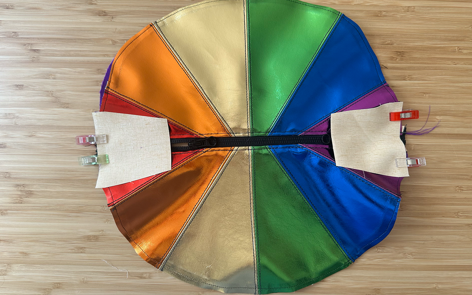 Seitenlaschen und Einlage an den Seiten der Regenbogen-Umhängetasche befestigt