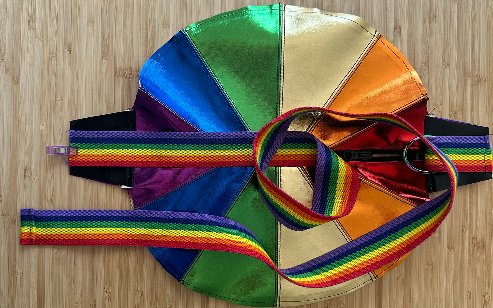 Regenbogenfarbener Gurt mit O-Ringen, der an einer regenbogenfarbenen Ledertasche befestigt ist