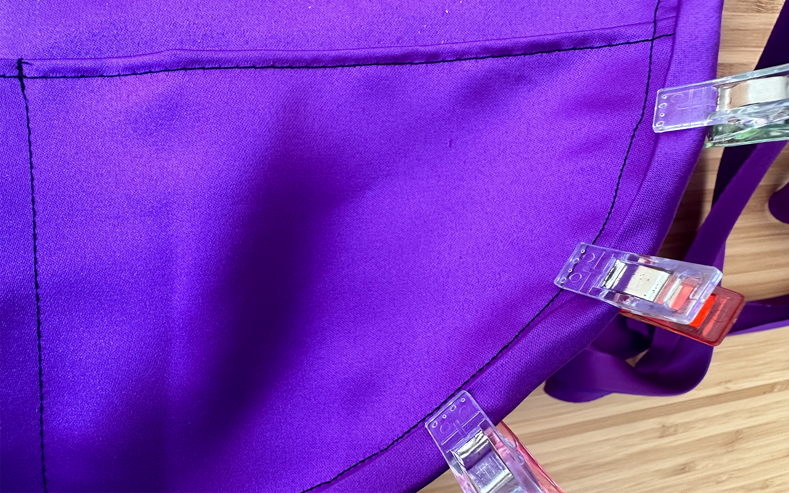 bias tape made from purple satin clipped to edge of purple satin bag