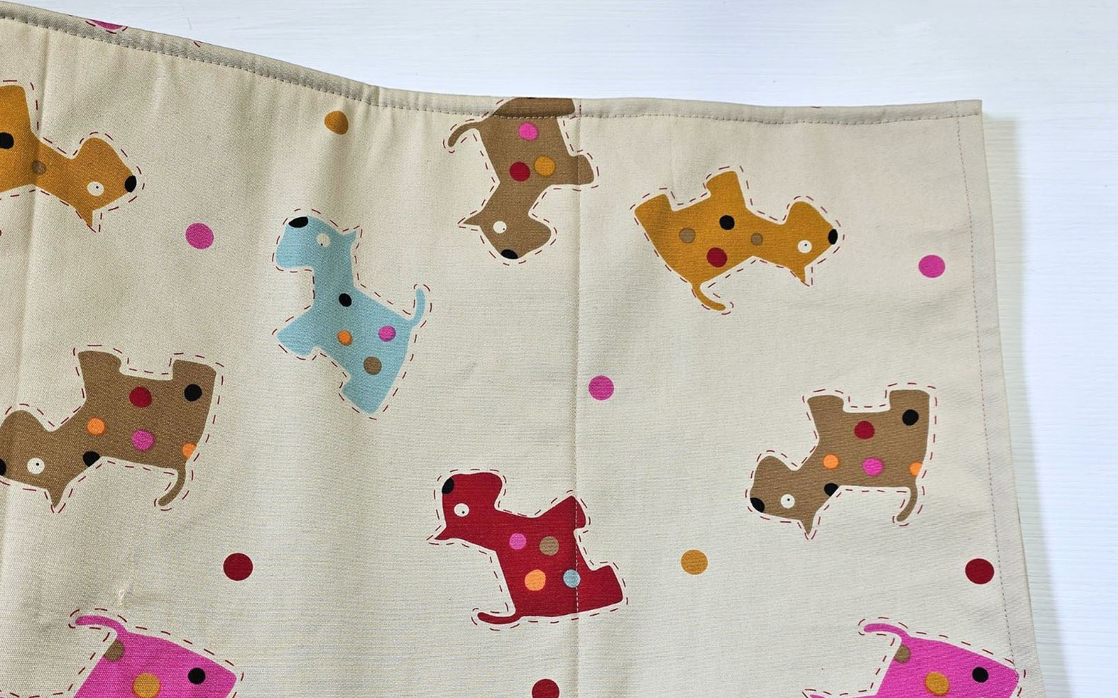 Cream fabric with different coloured dog pattern