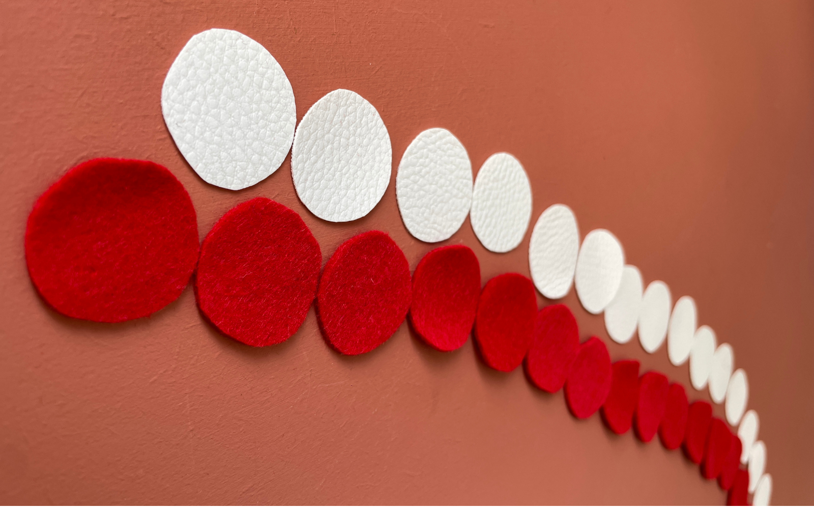 multiple circles of red felt and white pleather 