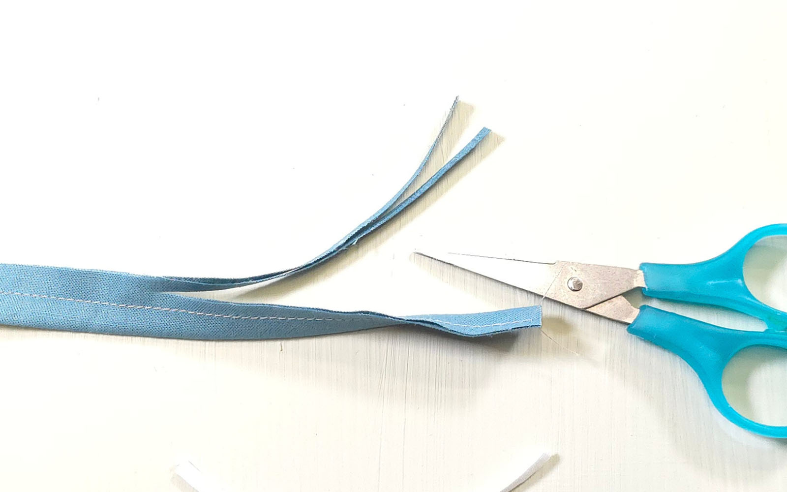 ciseaux bleus à côté d'une bande de tissu bleu