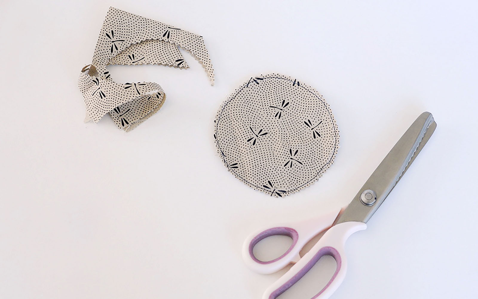 pinking shears next to cut beige circle fabric