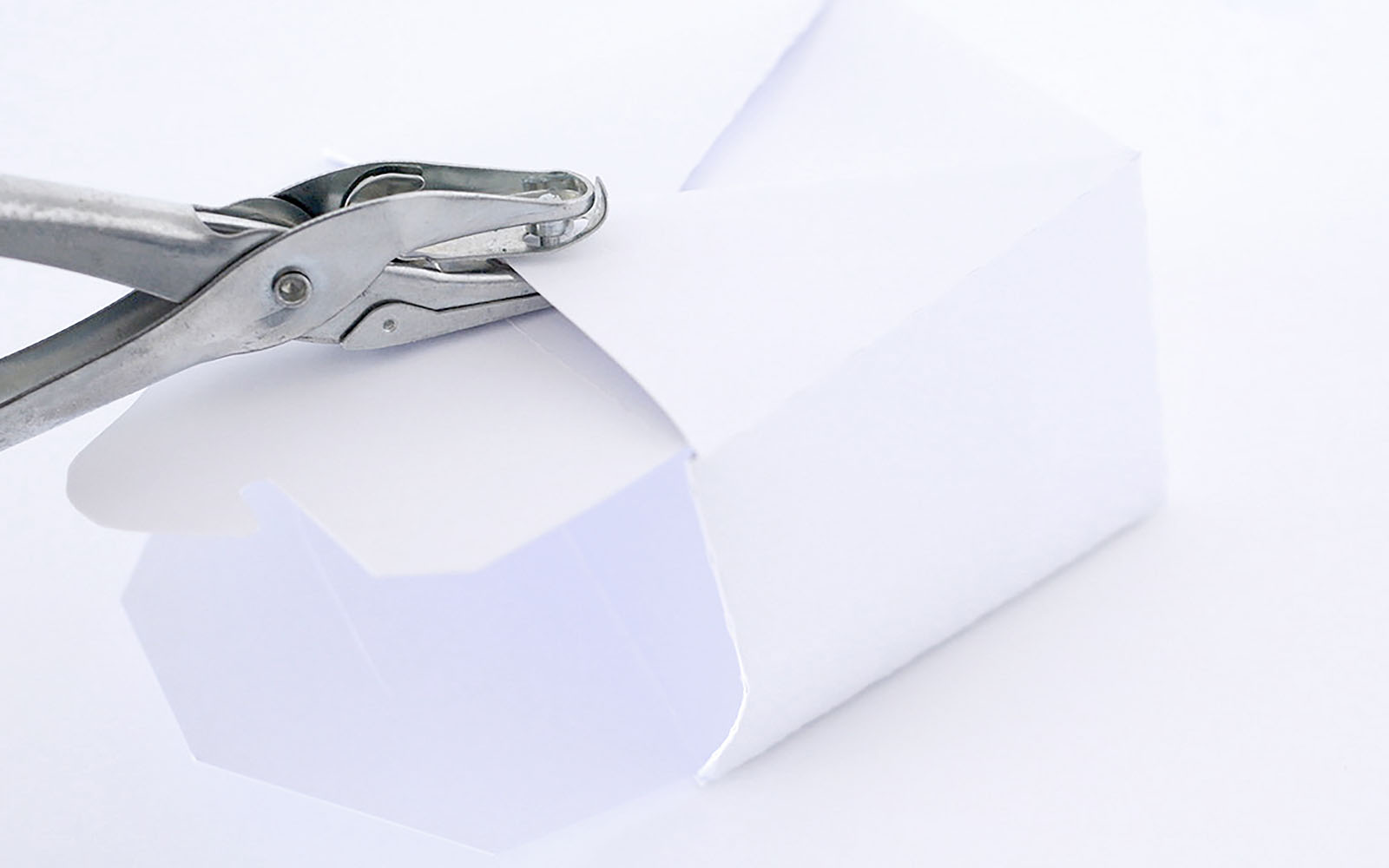 perforator maakt gat in witte kartonnen afhaaldoos