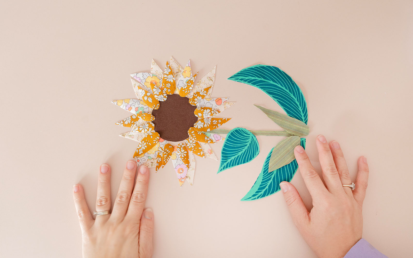 Mani che posizionano forme di fiori di applicazione