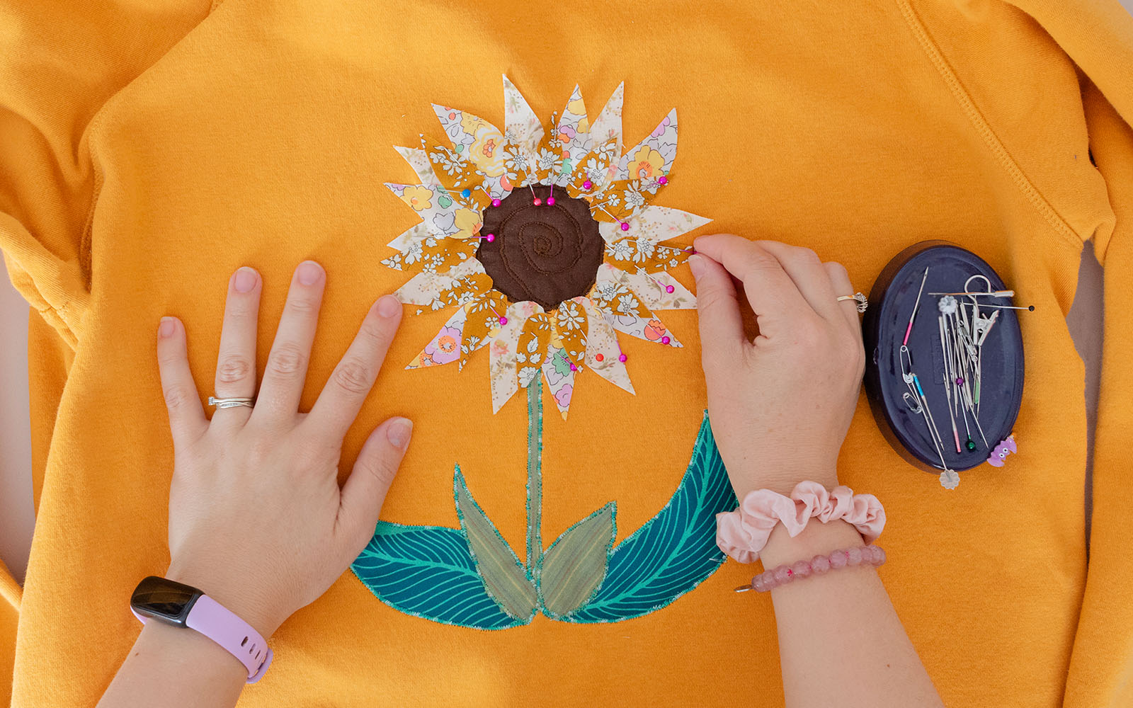 mains plaçant les pétales de fleurs en tissu à leur emplacement