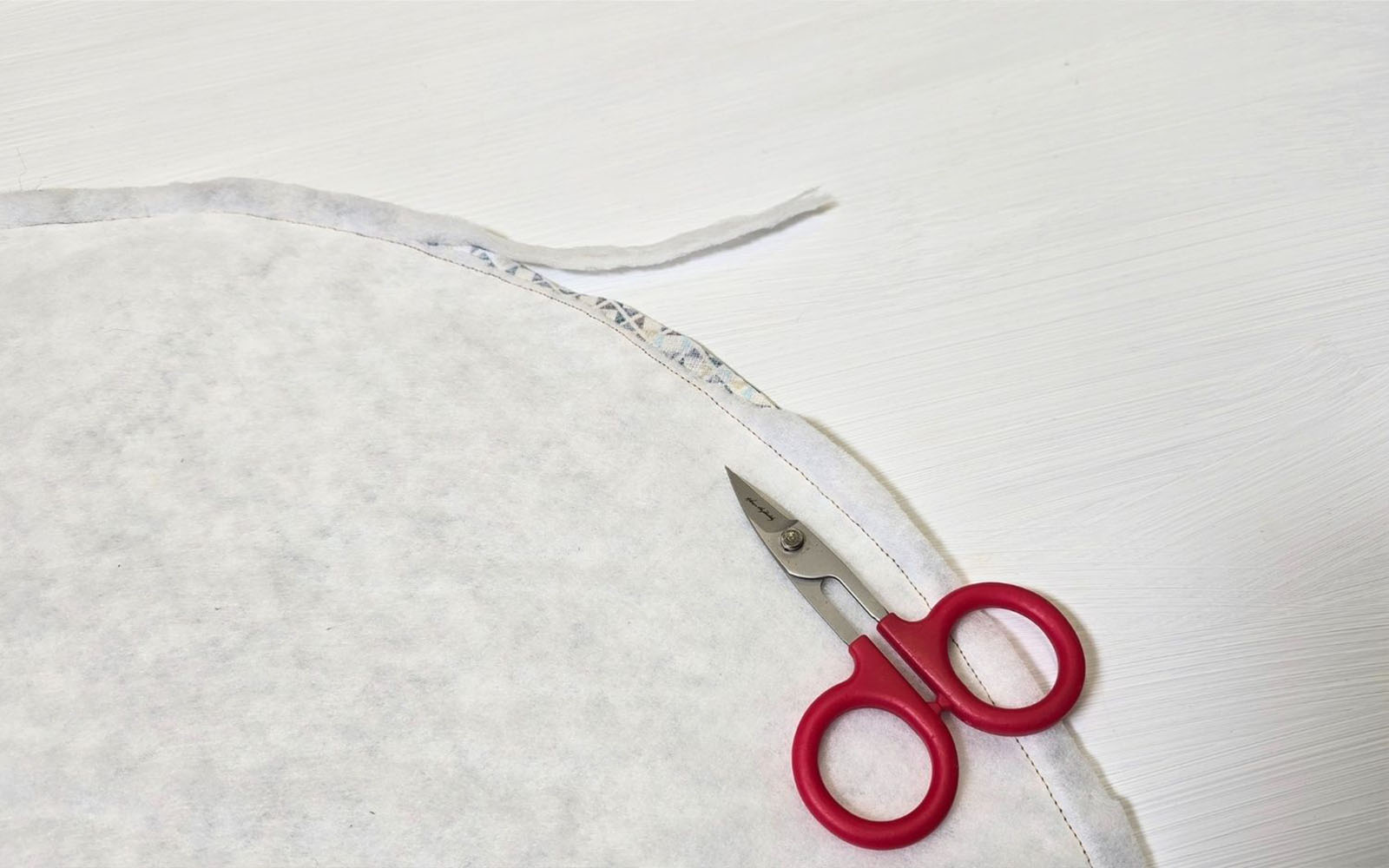 Scissors trimming batting out of bag seam