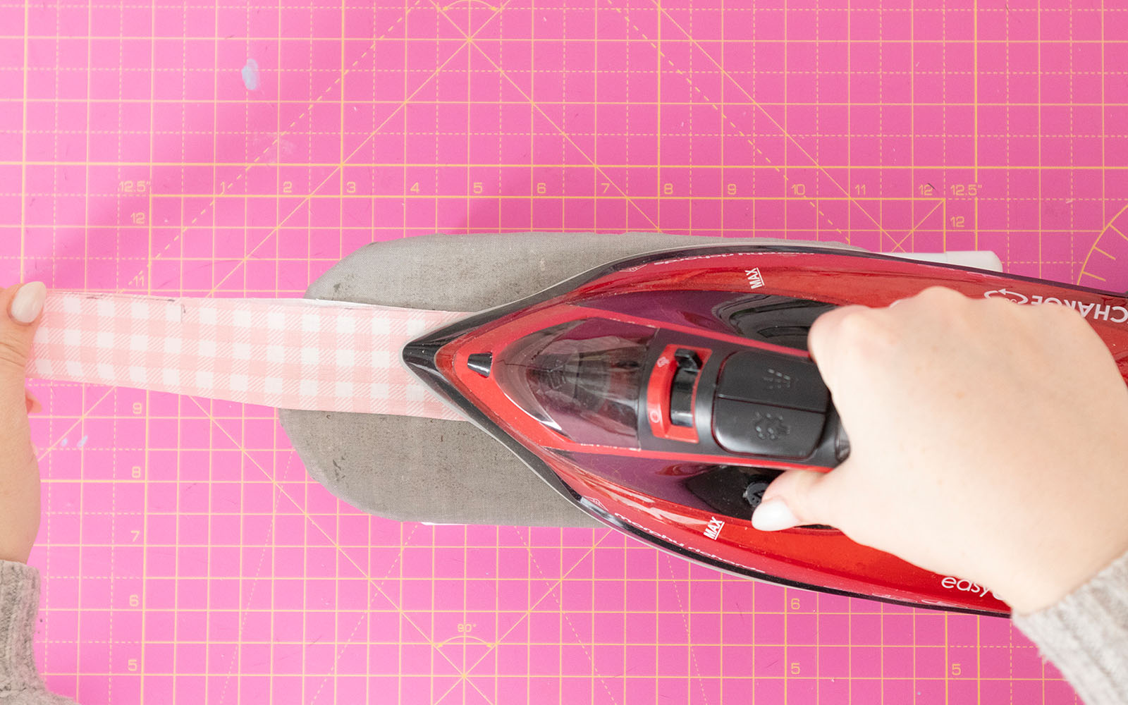 Ironing pink gingham strip to make bag strap