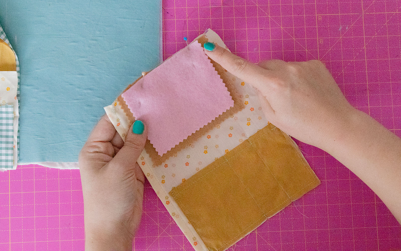 hands holding three colours of felt pinned together