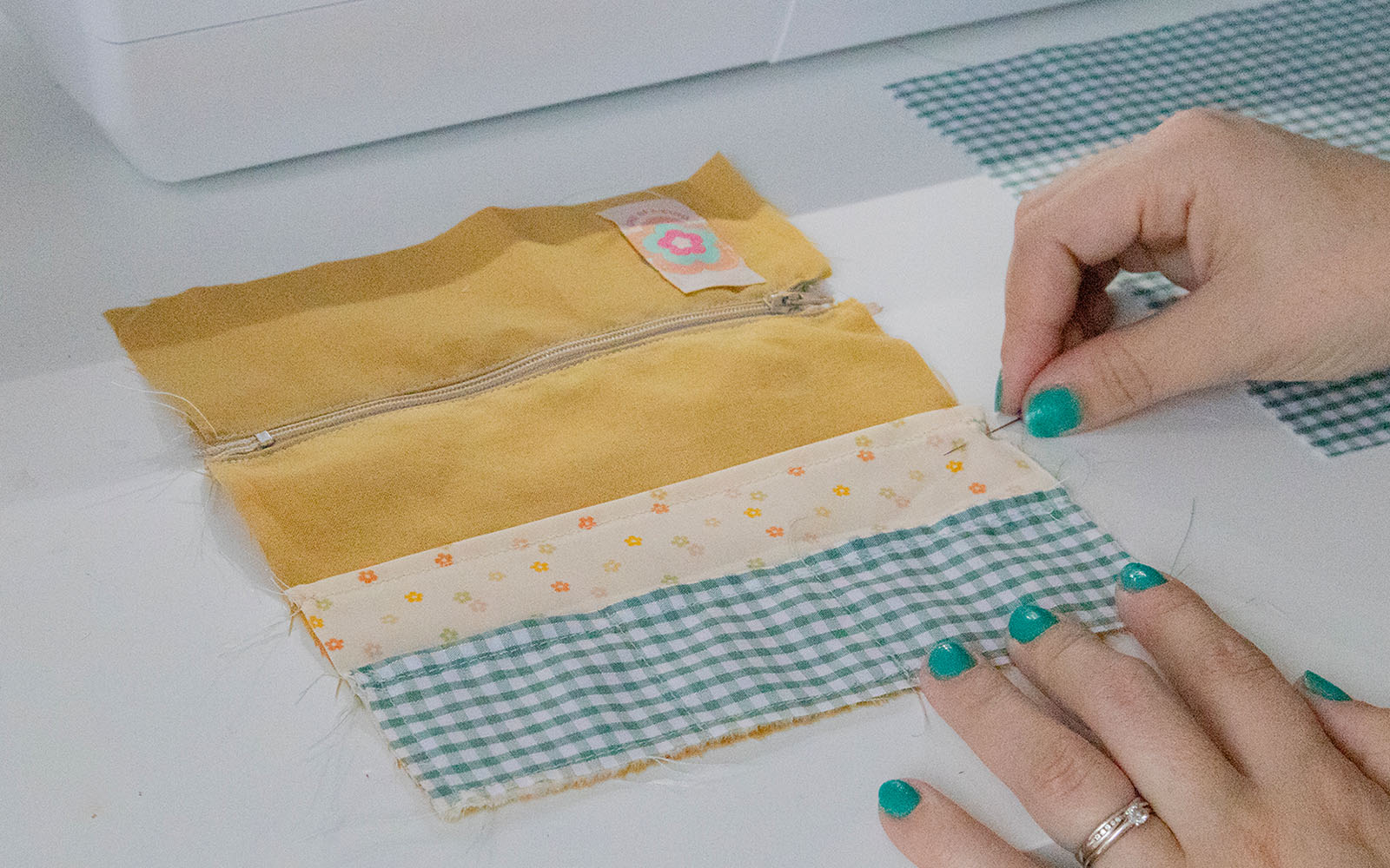 pinning floral and gingham fabric onto mustard fabric
