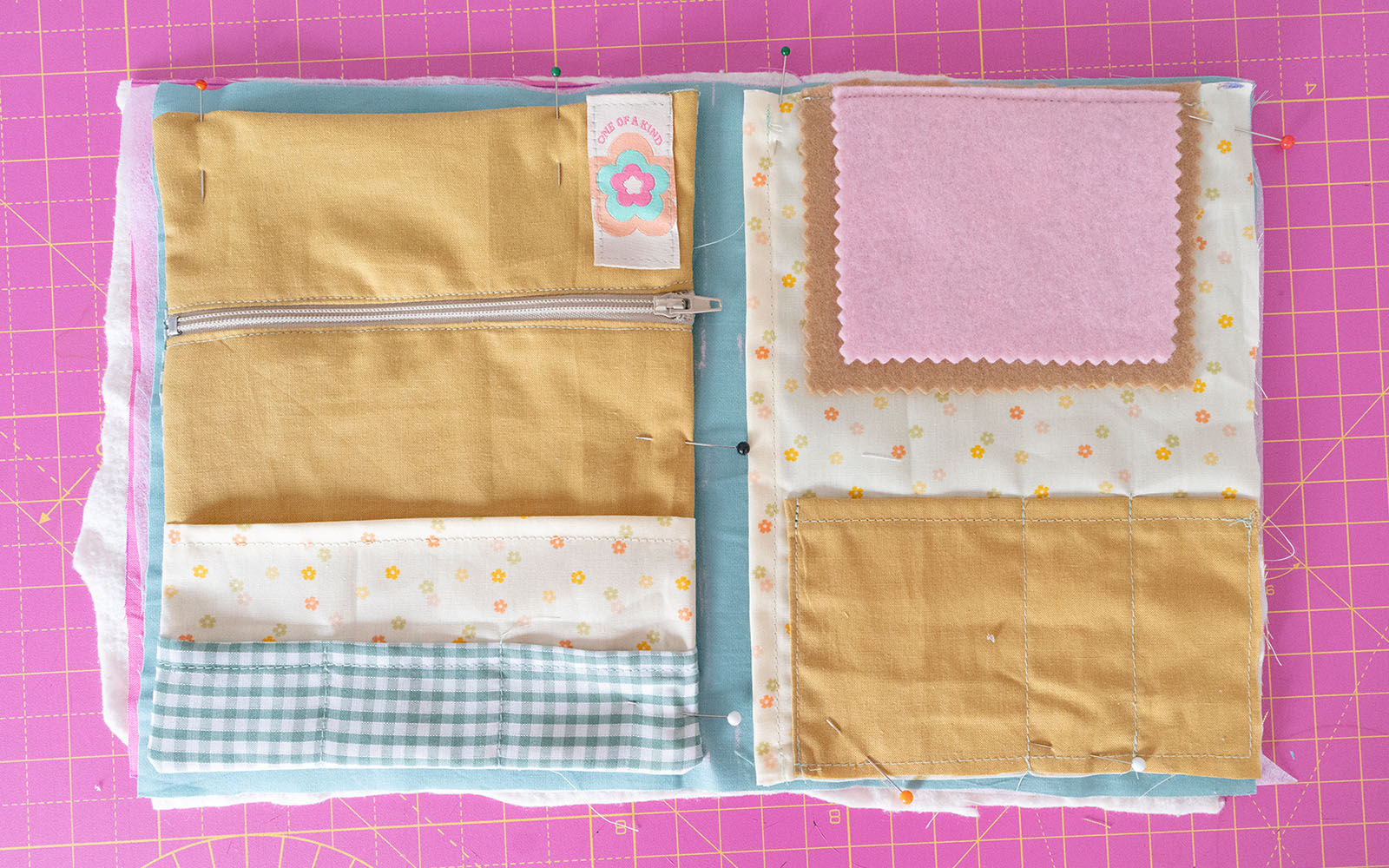 layers of needle book pinned together on pink cutting mat