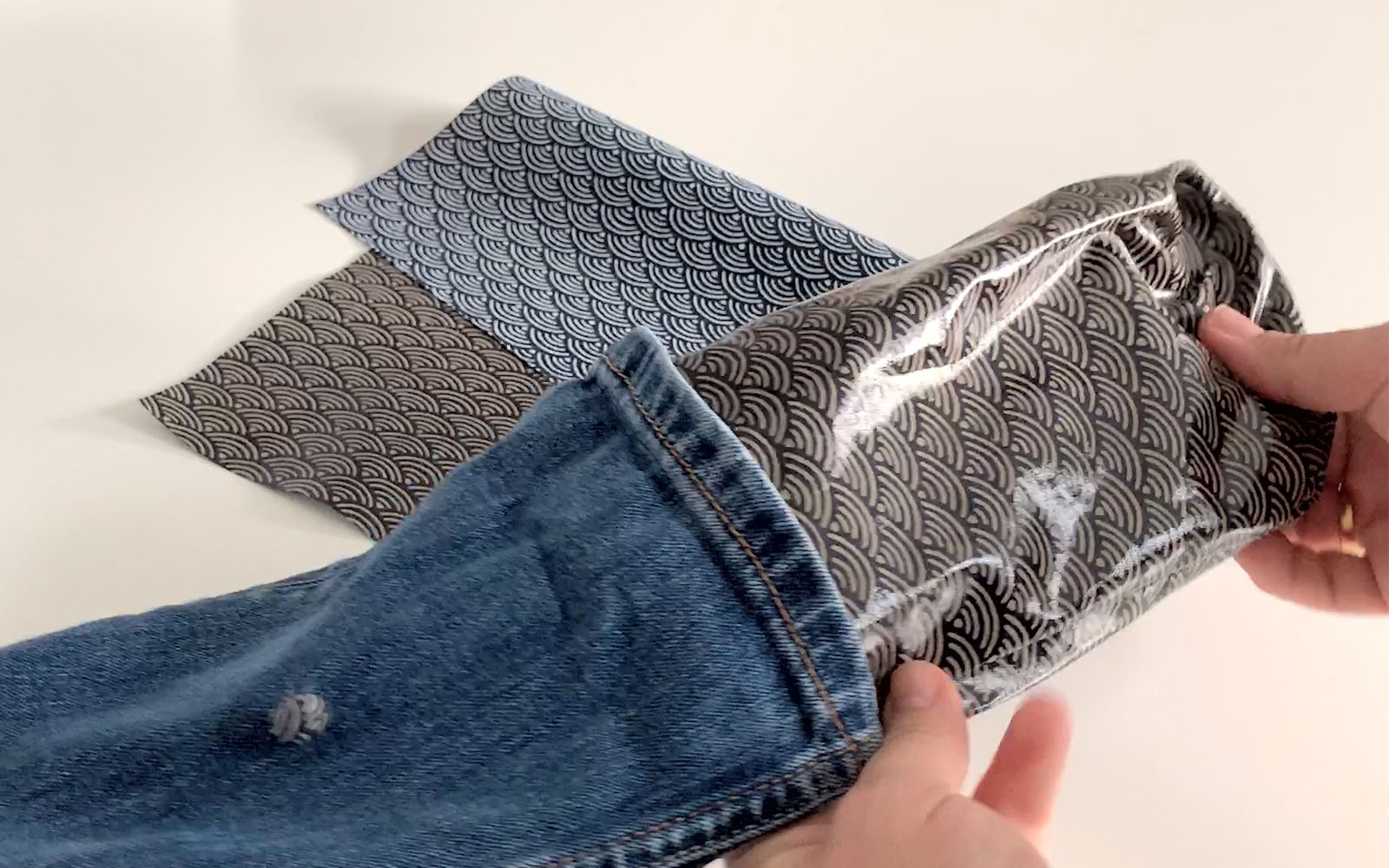 blue denim lunch bag with hand pulling oil cloth lining out
