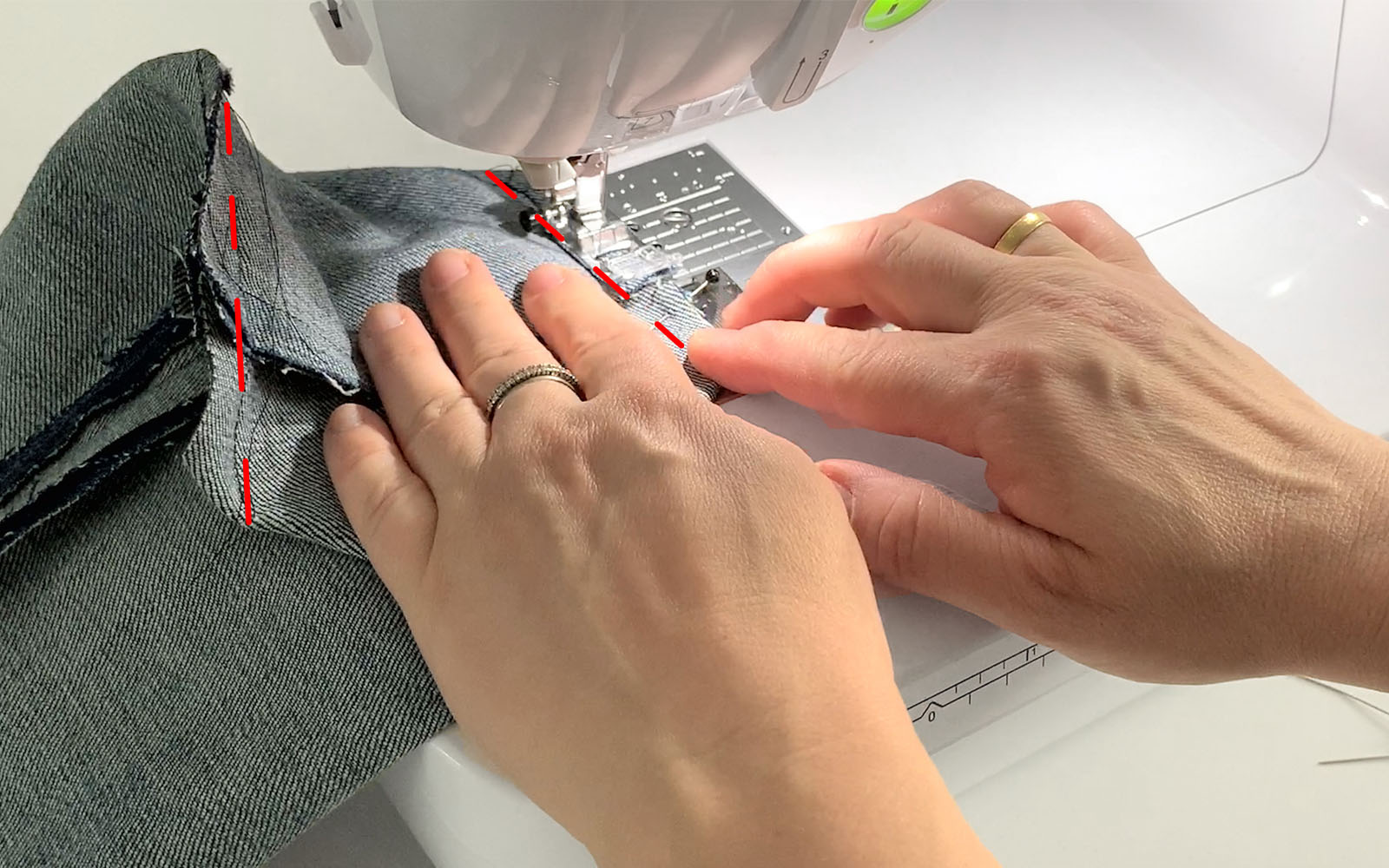 Square denim bag being sewn along bottom seam