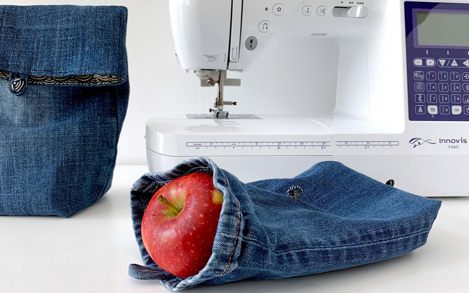 Machine à coudre Brother avec un petit sac en denim à l'avant.