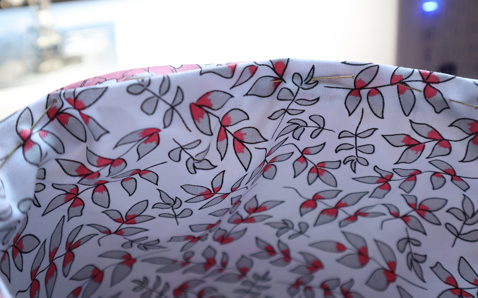 Pinned pink leaf fabric in front of Brother NV1800Q sewing and quilting machine