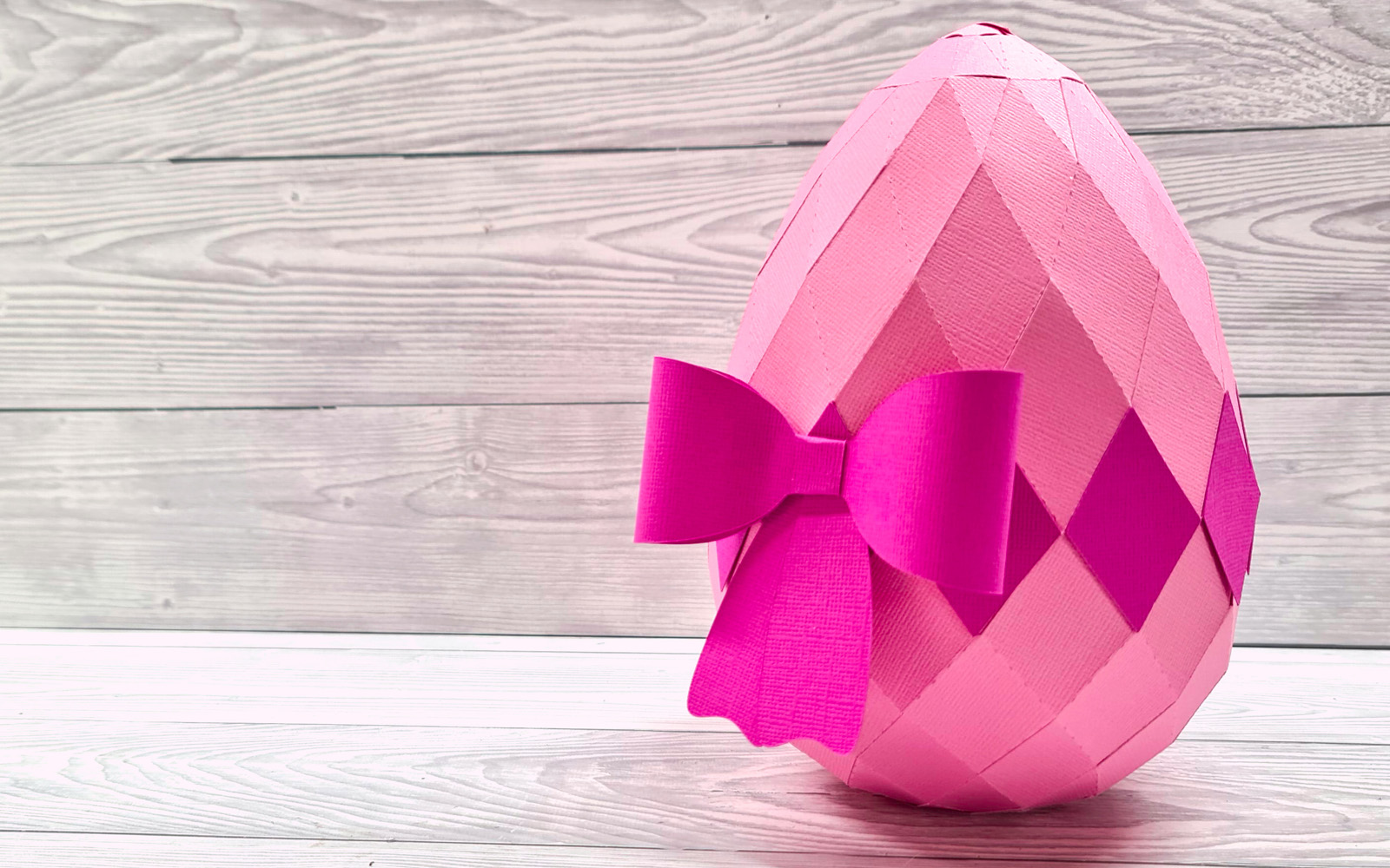 œuf de Pâques en papier sur fond de bois