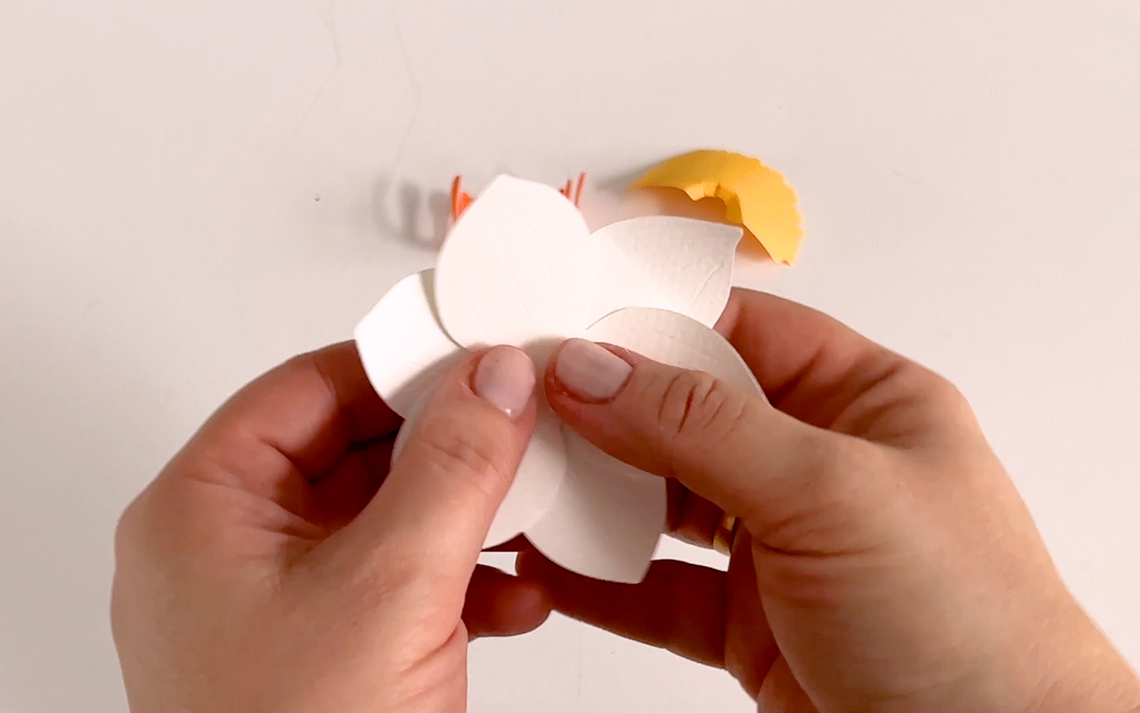 gluing two white papercraft flowers one on top of the other