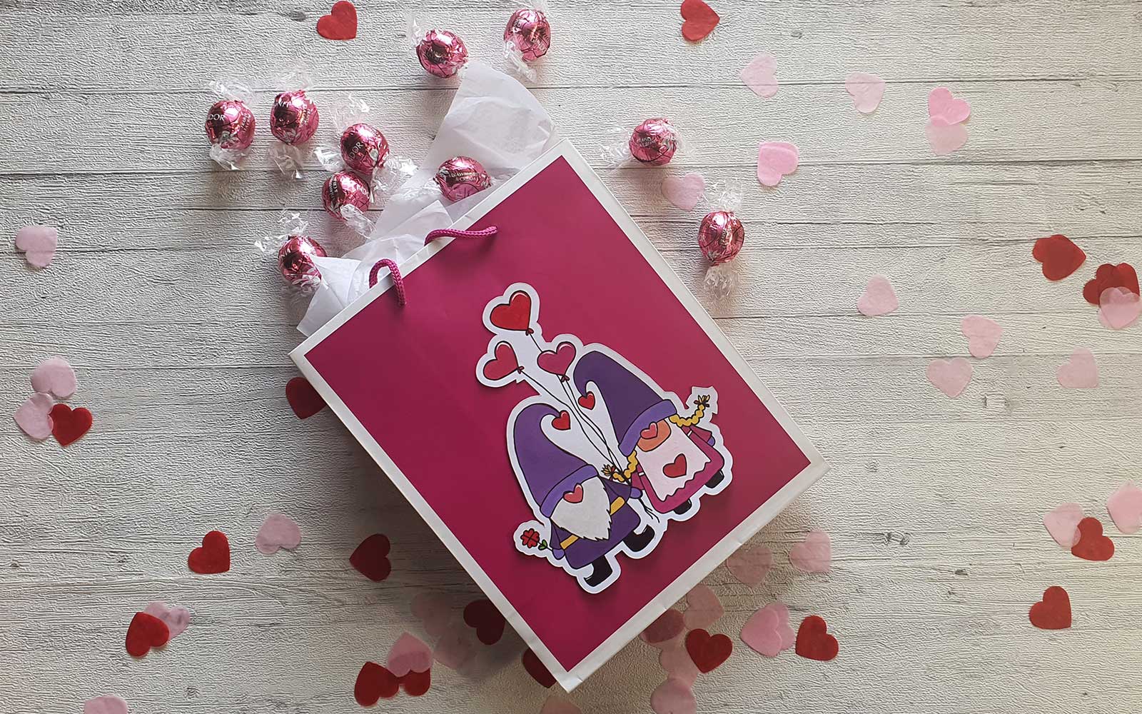 Geschenktüte mit bunten Liebeswichteln auf der Vorderseite