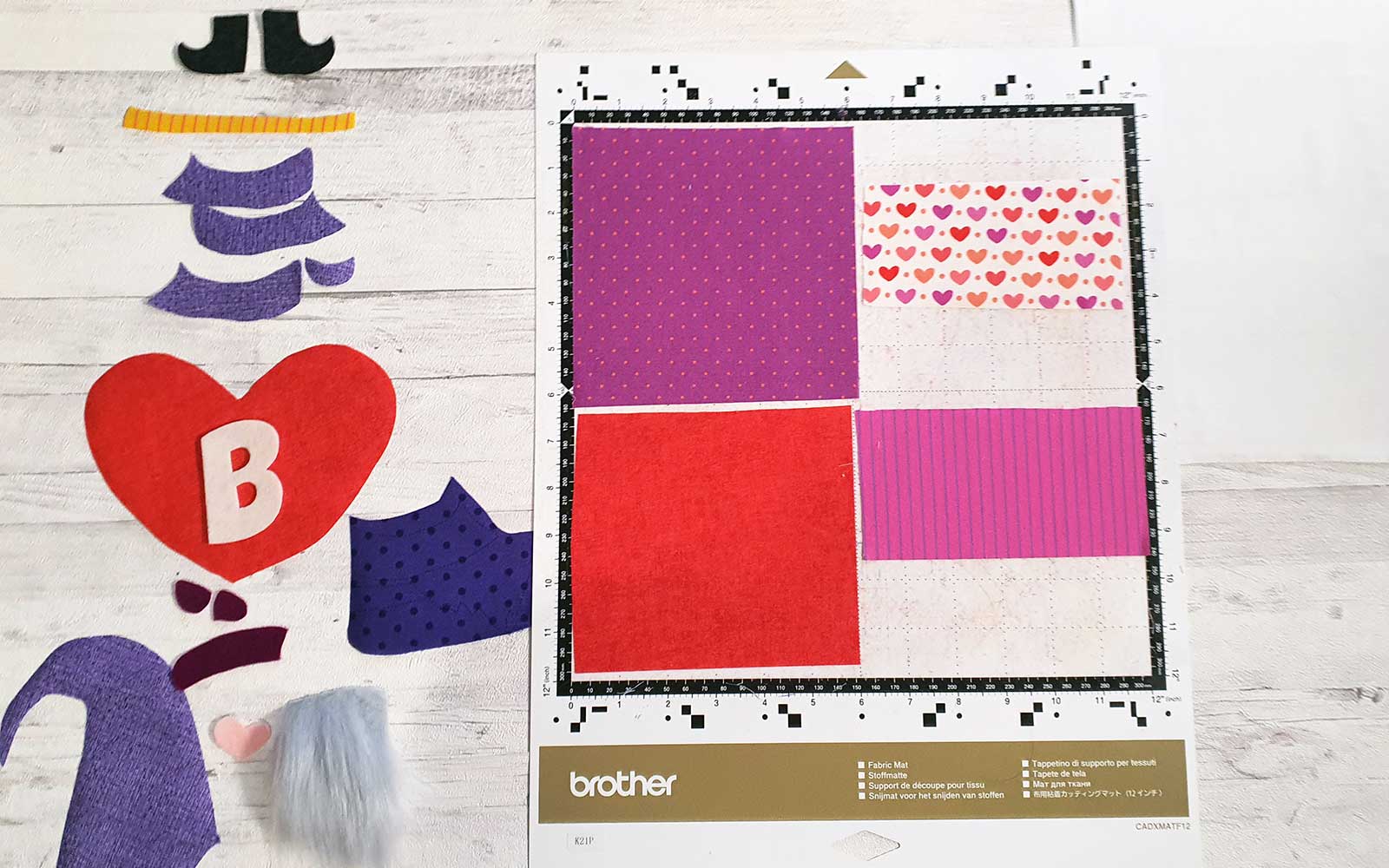 Various fabric pieces cut out of fabric and on mat