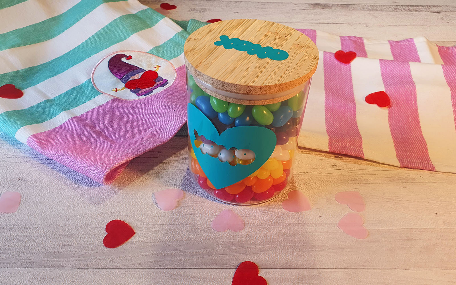 Einmachglas mit besticktem Handtuch im Hintergrund