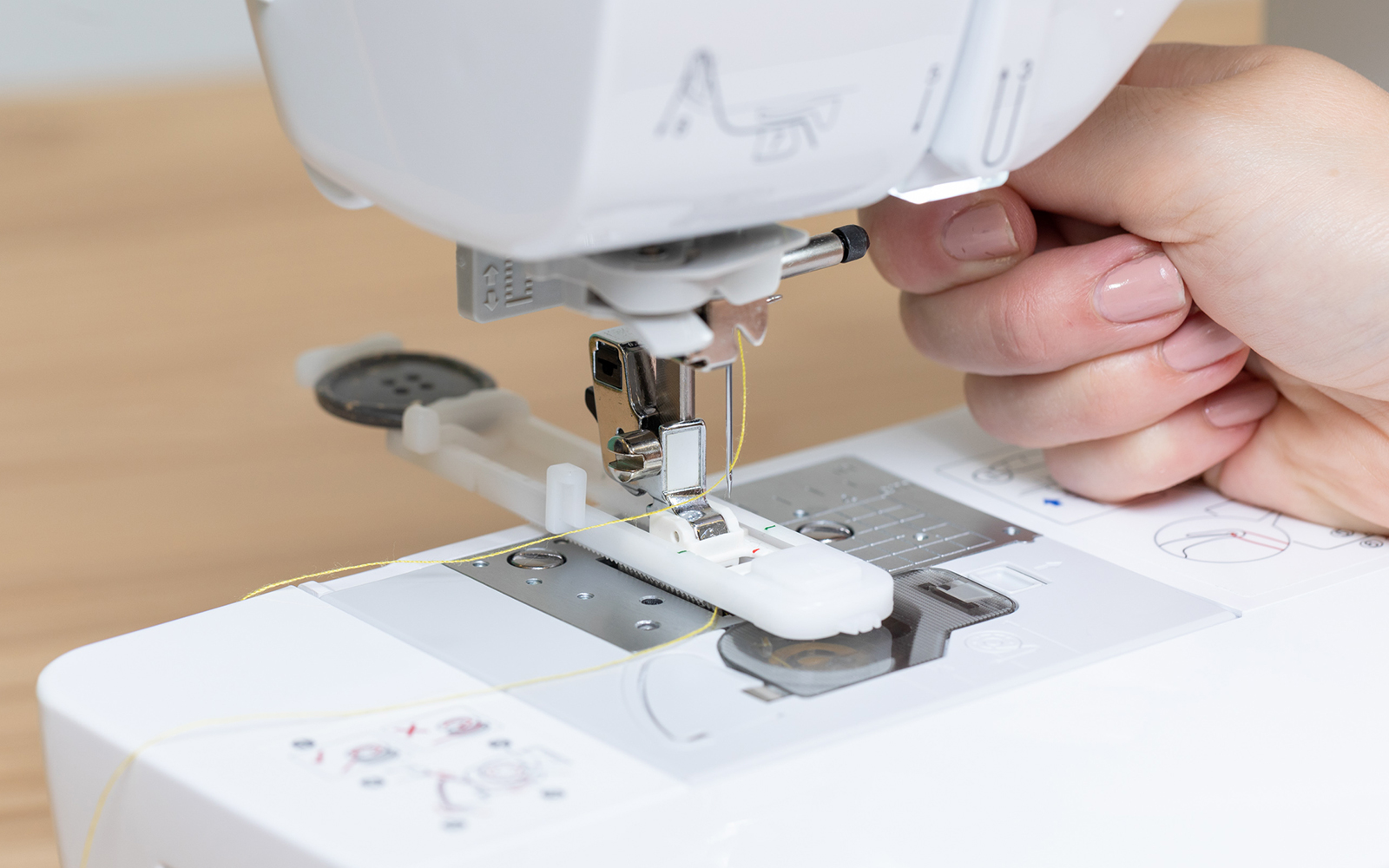 Hand on presser foot lever on Brother sewing machine