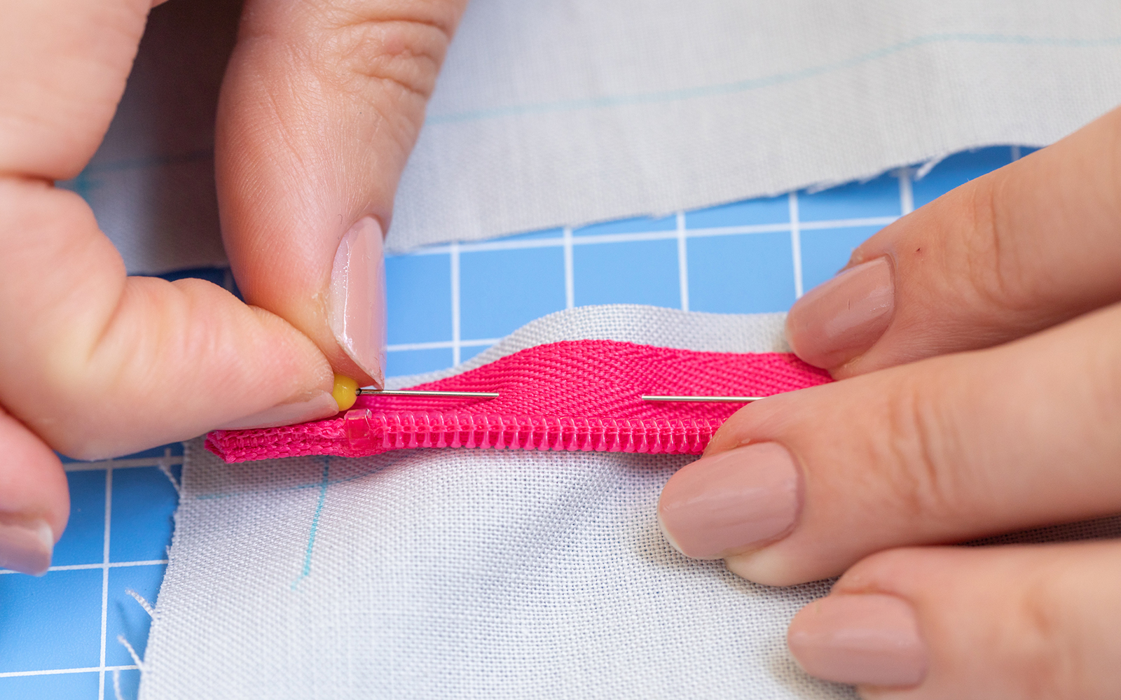 Hands pinning invisible zipper in place