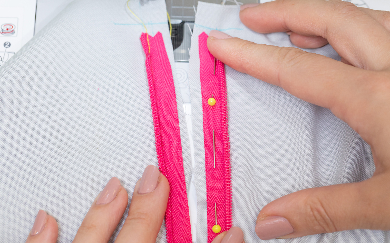 Handen die roze verborgen ritssluiting op zijn plaats houden