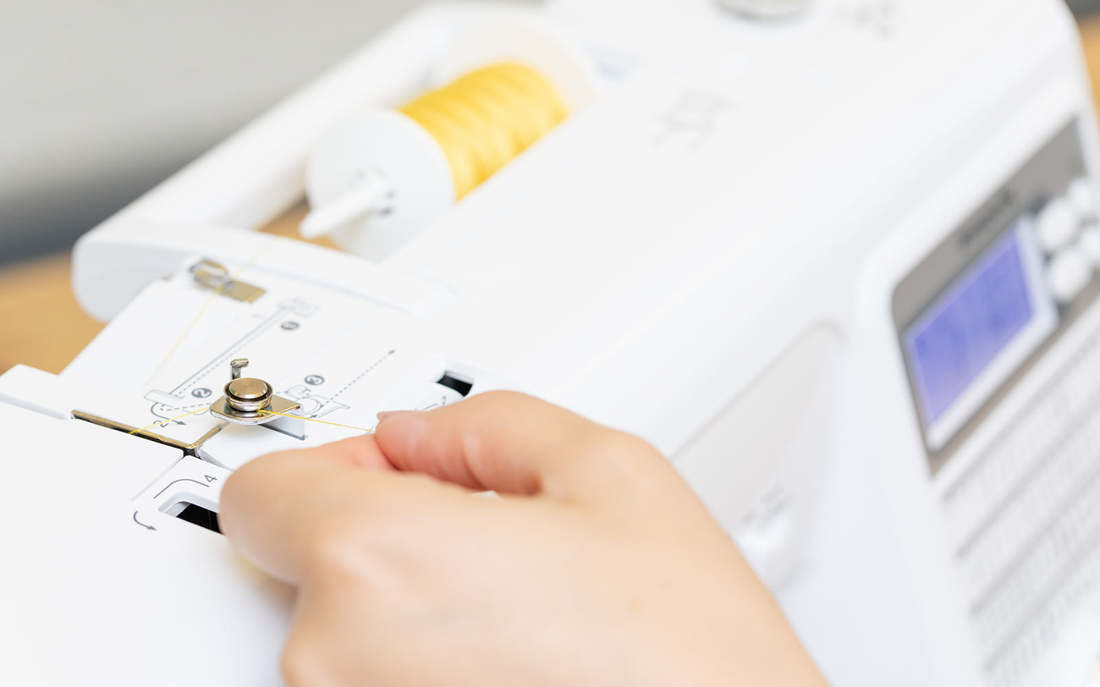 Einfädeln des gelben Fadens in die Brother-Nähmaschine