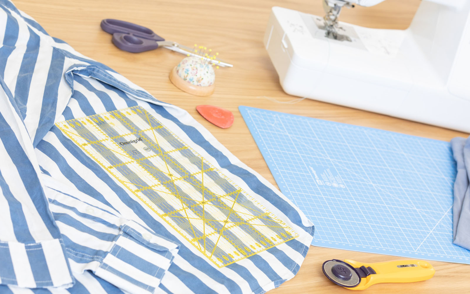 Blue and white shirt and sewing materials on table