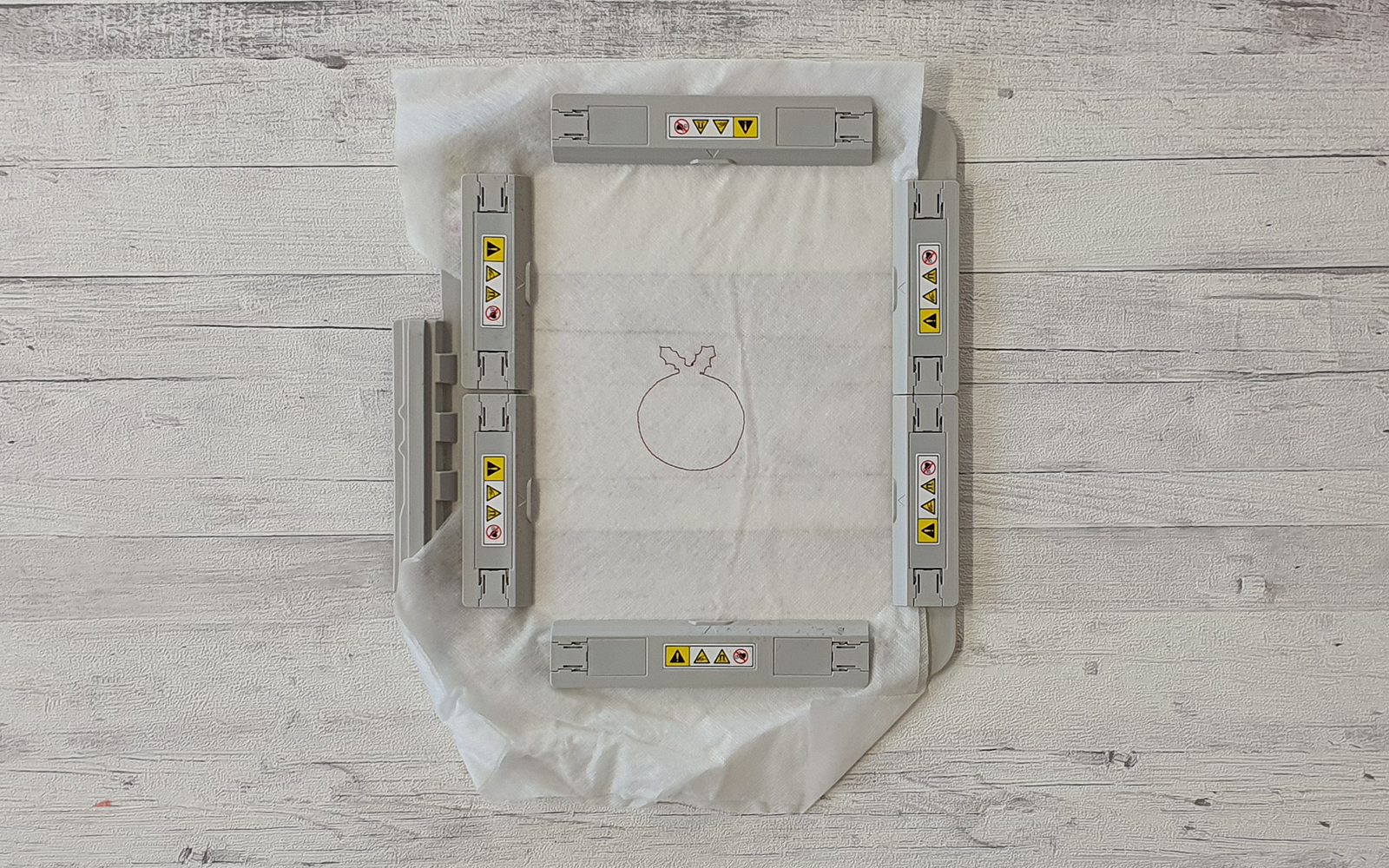 Brother magnetic embroidery frame with stabiliser on white wooden background