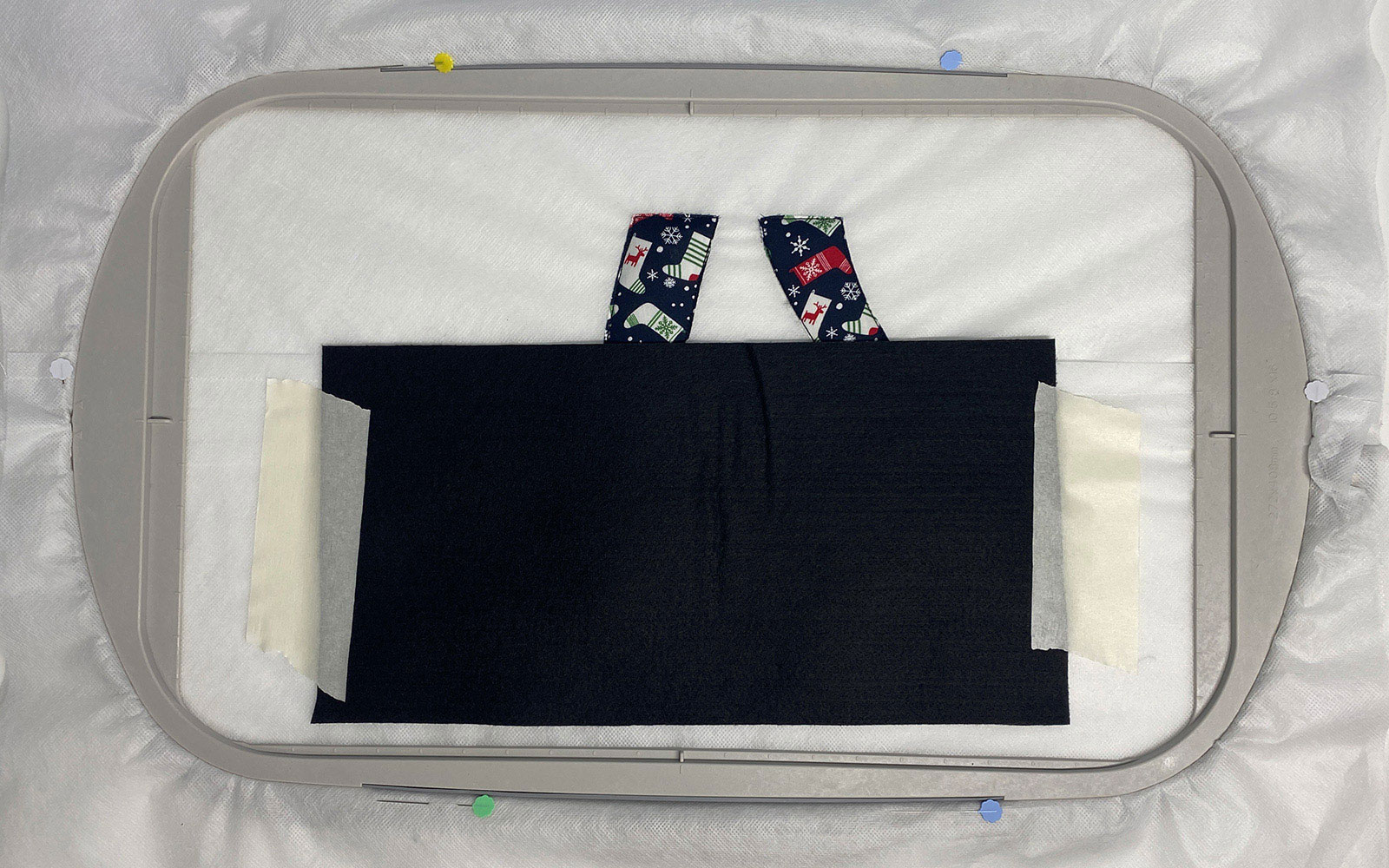 Stoff mit Klebeband auf Stickvlies im Stickrahmen