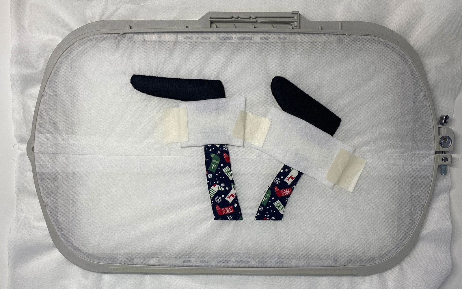 Stoff mit Klebeband auf Stickvlies im Stickrahmen