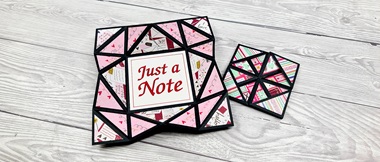 Carte rose pliée façon cocotte portant la mention