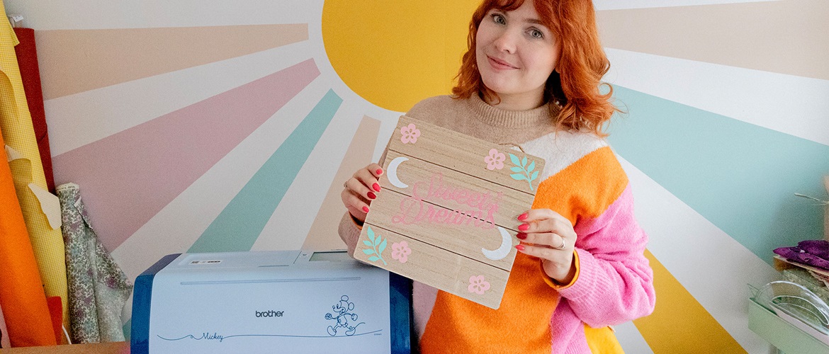 Paige Joanna holds Sweet Dreams wall sign with Brother ScanNCut