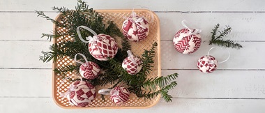 Weidenkorb mit roten und weißen Weihnachtskugeln aus Stoff