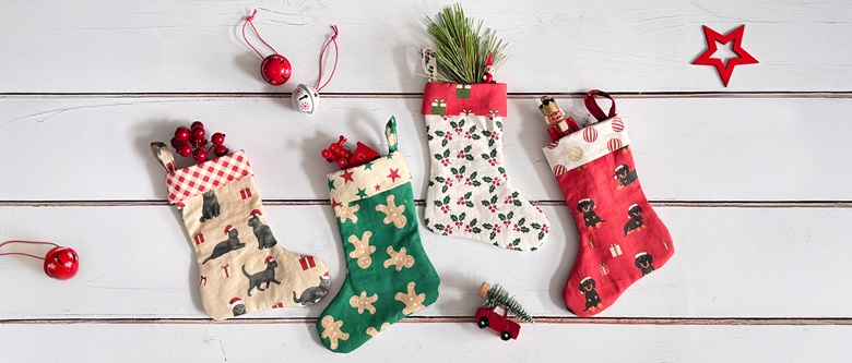 Quatre chaussettes de Noël imprimées sur tissu avec différents motifs.