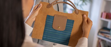 Woman holding a brown corduroy handbag