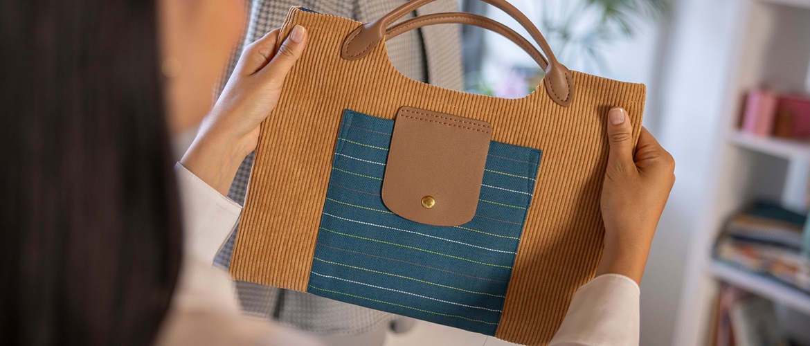 Woman holding a brown corduroy handbag