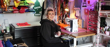 Woman sits at wooden desk with Brother sewing machine