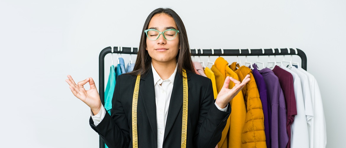 Femme avec un ruban à coudre méditant devant des vêtements