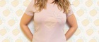 Vrouw draagt ​​roze t-shirt met geborduurde ananas op de voorkant