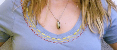 Femme portant un t-shirt bleu avec des points décoratifs autour du cou
