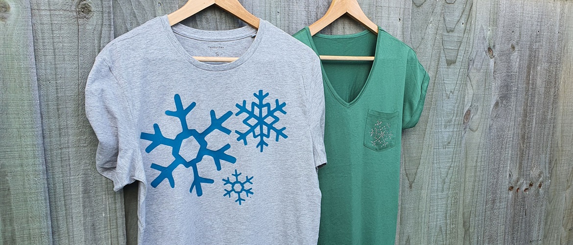 2 Christmas T-shirts hanging on fence