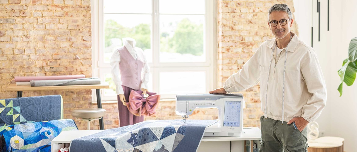 Man with hand on Celeste CX1 sewing machine in sewing studio