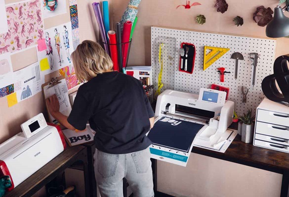 Une femme dans un atelier de bricolage avec plusieurs ScanNCuts de Brother