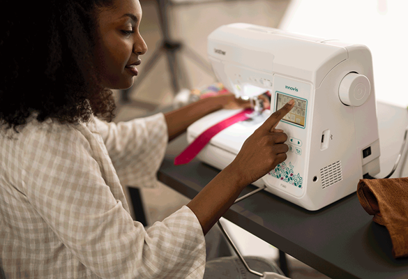 jeune femme changeant les réglages sur la machine coudre Brother F560