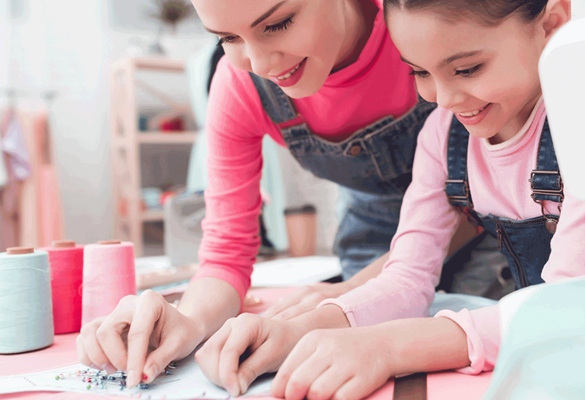 Mère et fille dans une salle de couture travaillant sur un projet.