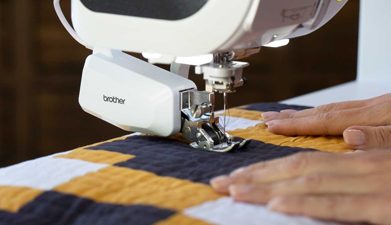 Close up of Brother dual feed and blue, white and yellow quilt